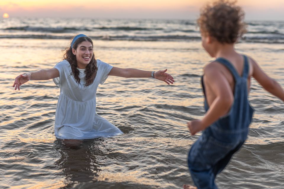 ילדים משתוללים במים בשקיעה
