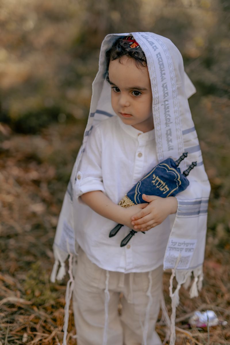 ילד בן שלוש עטוף בטלית בצילומי חלאקה